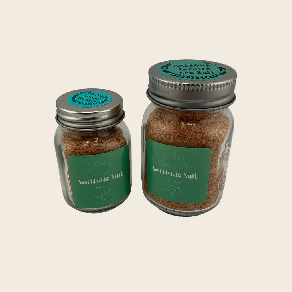 Two jars of Arizona infused sea salt with green labels on a light gray background