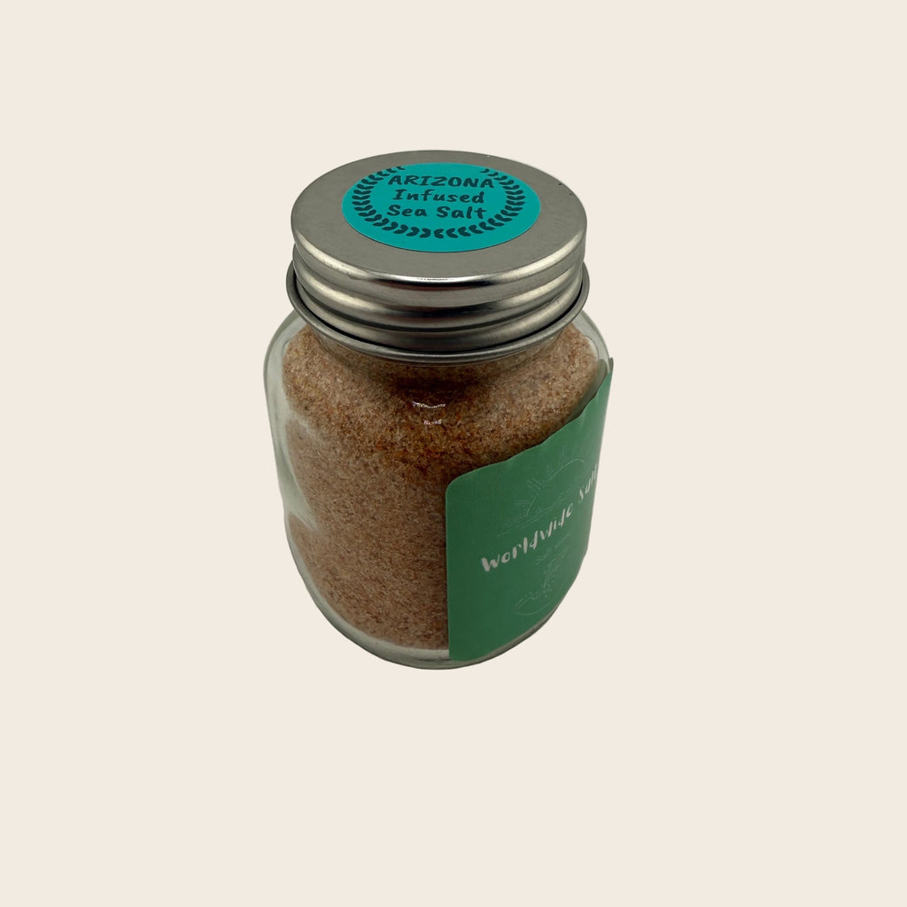 Jar of sea salt with a metal lid on a light gray background