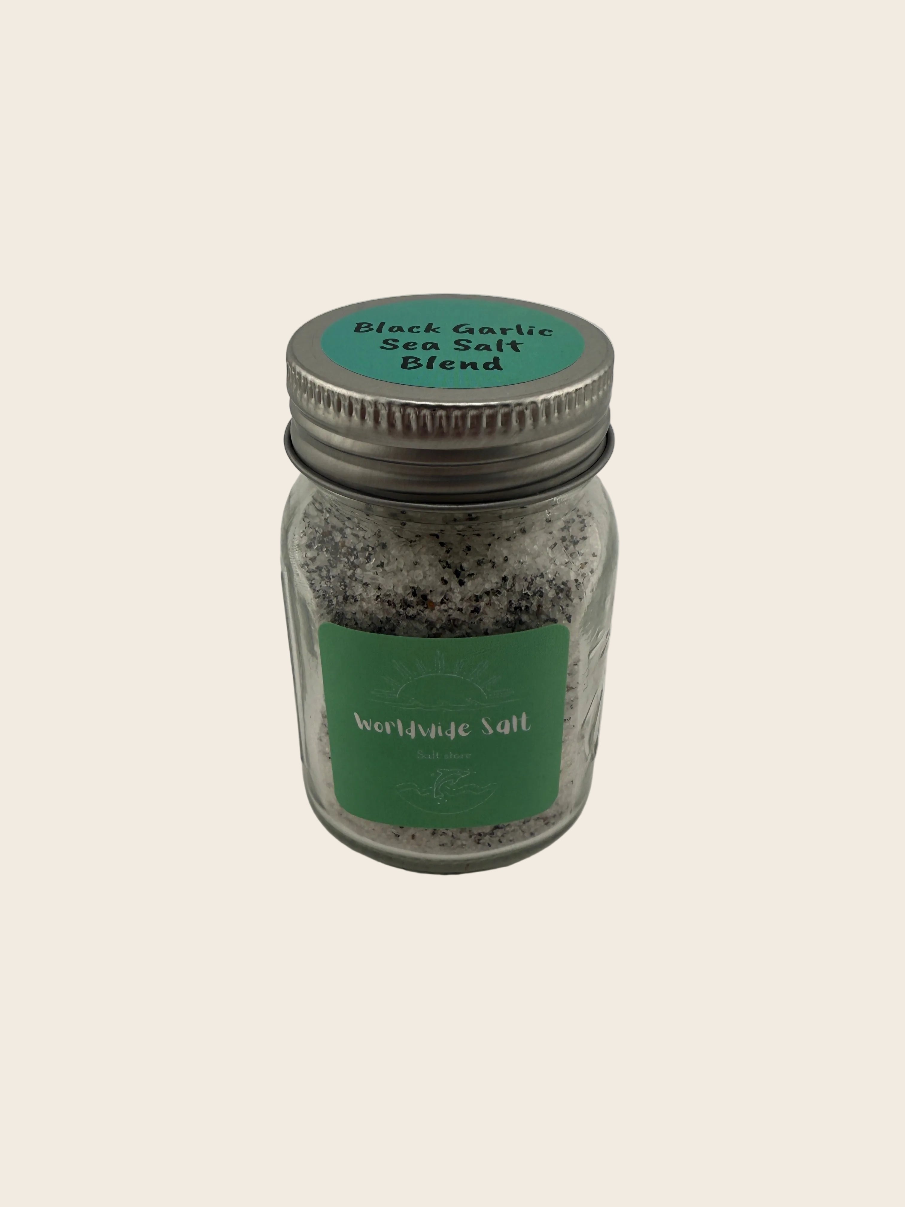 Jar of black garlic salt blend with a green label on a gray background