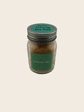 Jar of garlic infused sea salt with a green label on a gray background