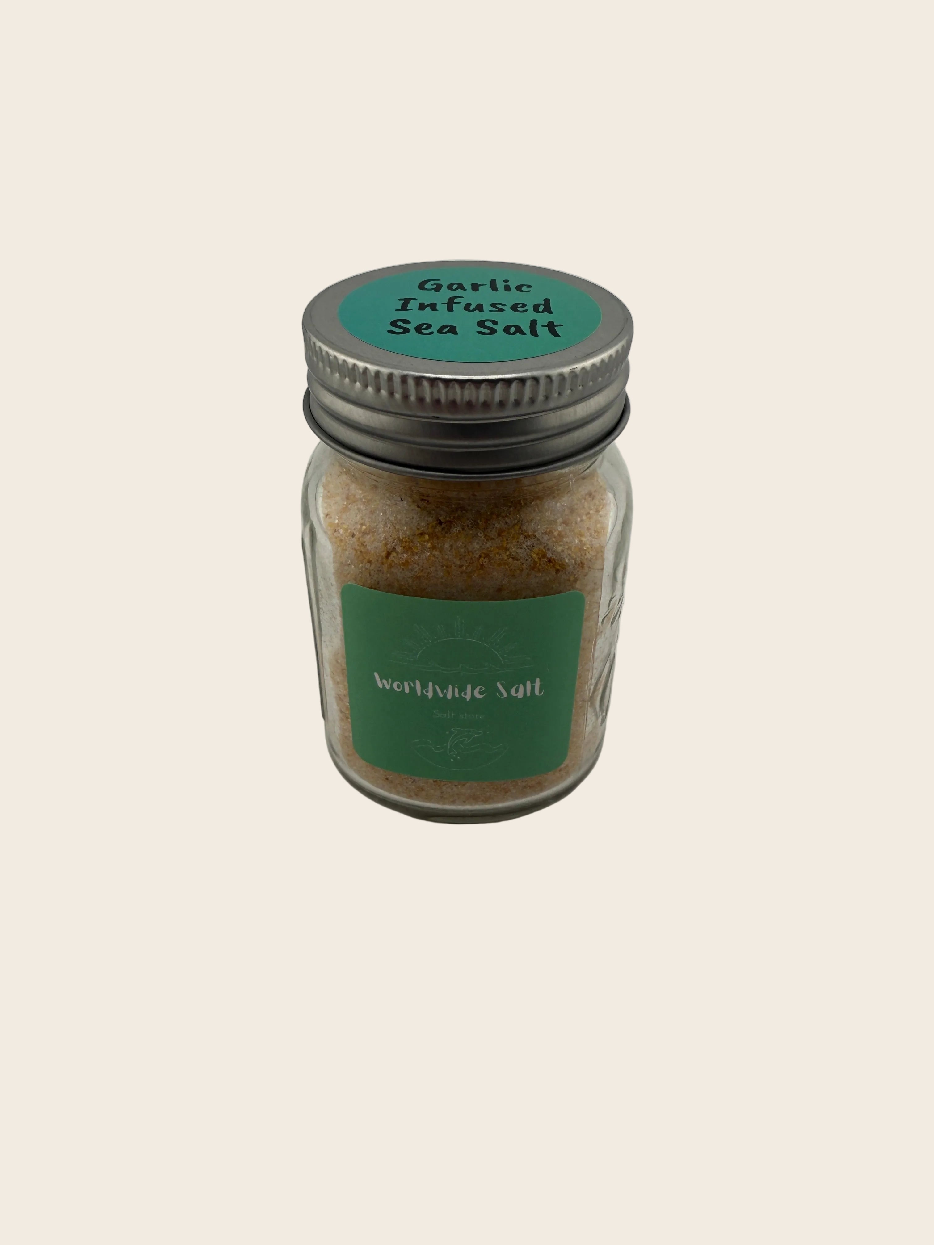 Jar of garlic infused sea salt with a green label on a gray background