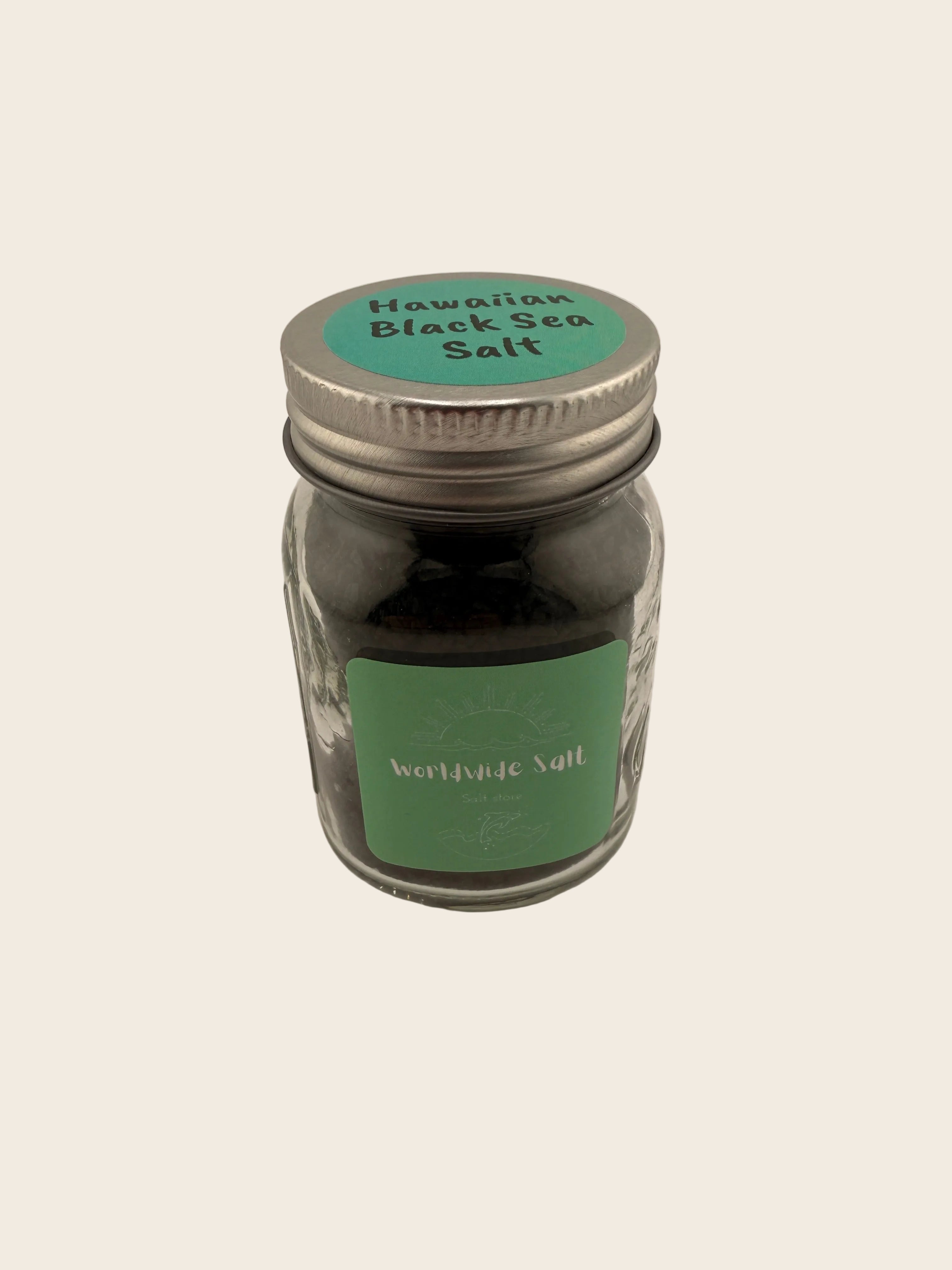 Jar of Himalayan black salt with green label on a beige background