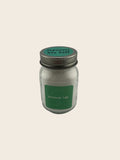 Small glass jar with a metal lid on a gray background