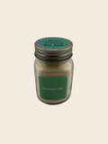 Jar of sea salt with a green label on a plain background