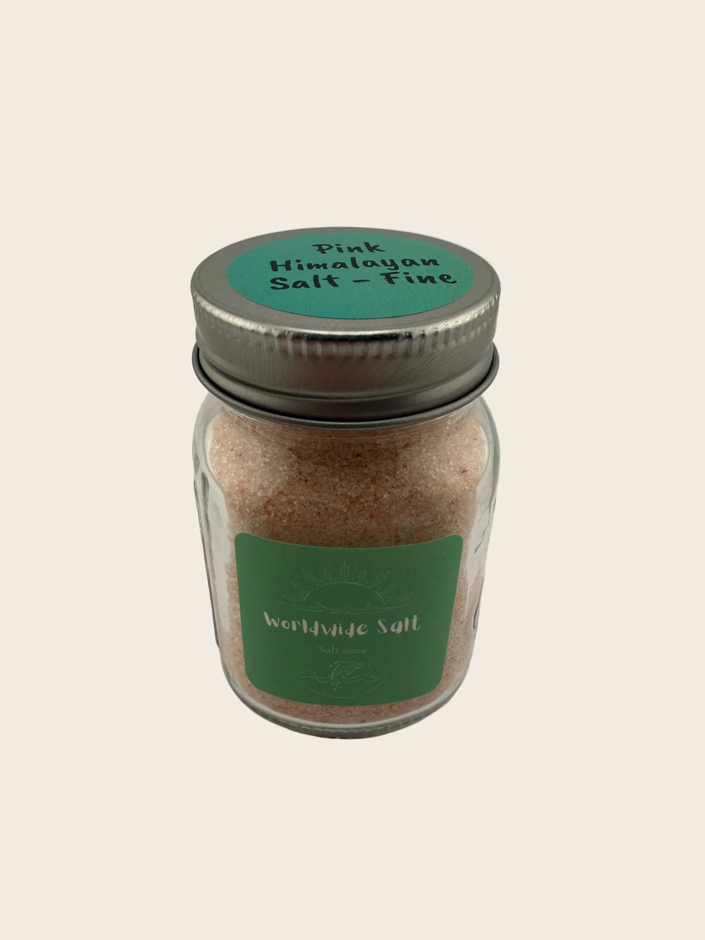 Jar of pink Himalayan salt with a green label on a light gray background