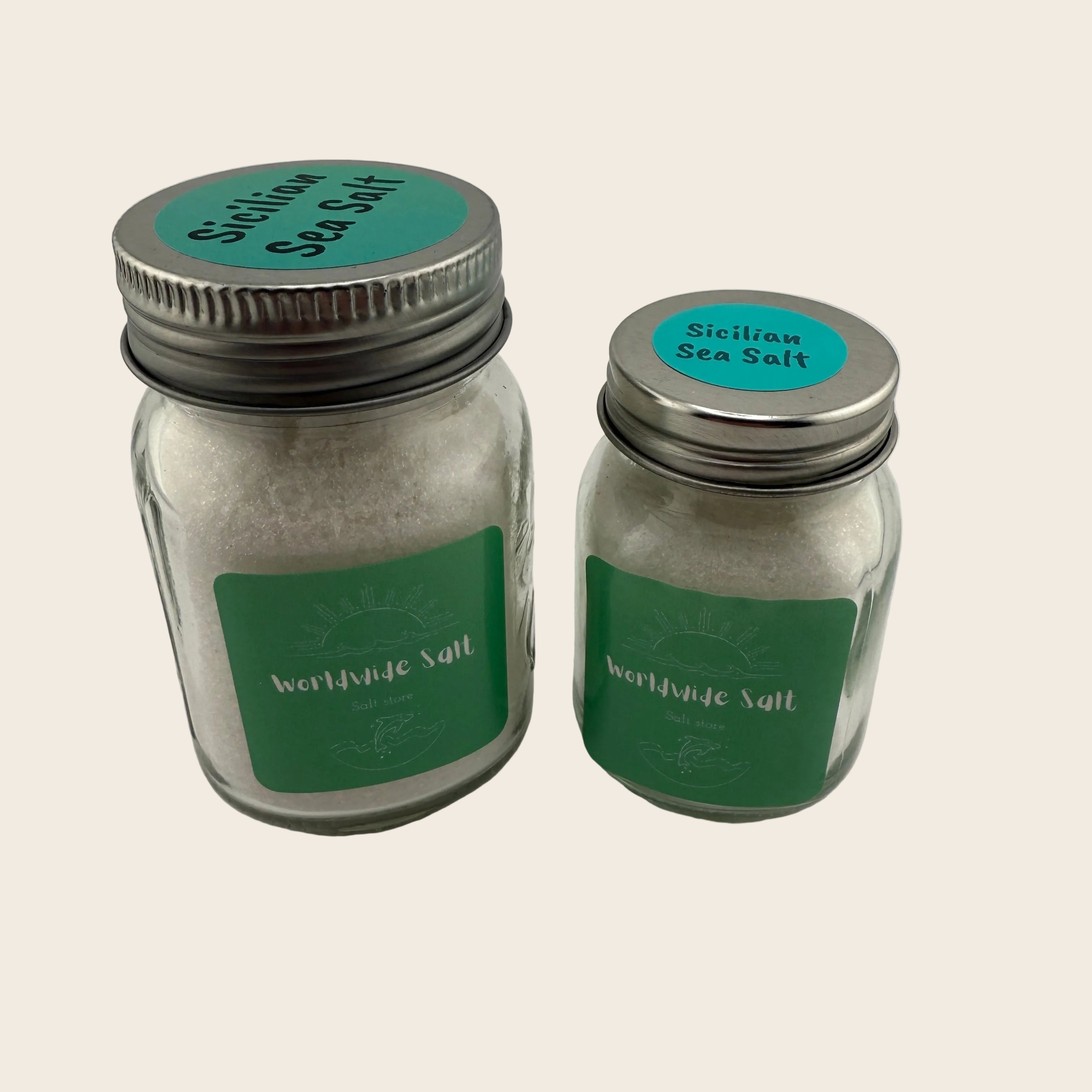 Two glass jars labeled 'Sicilian Sea Salt' with green labels on a light gray background.